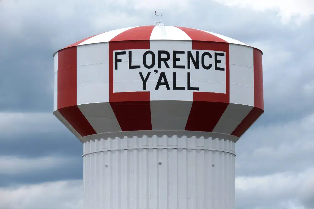 Florence Kentucky | Rollins Insurance Water tower with red and white stripes reading 'FLORENCE Y'ALL' against a cloudy sky.